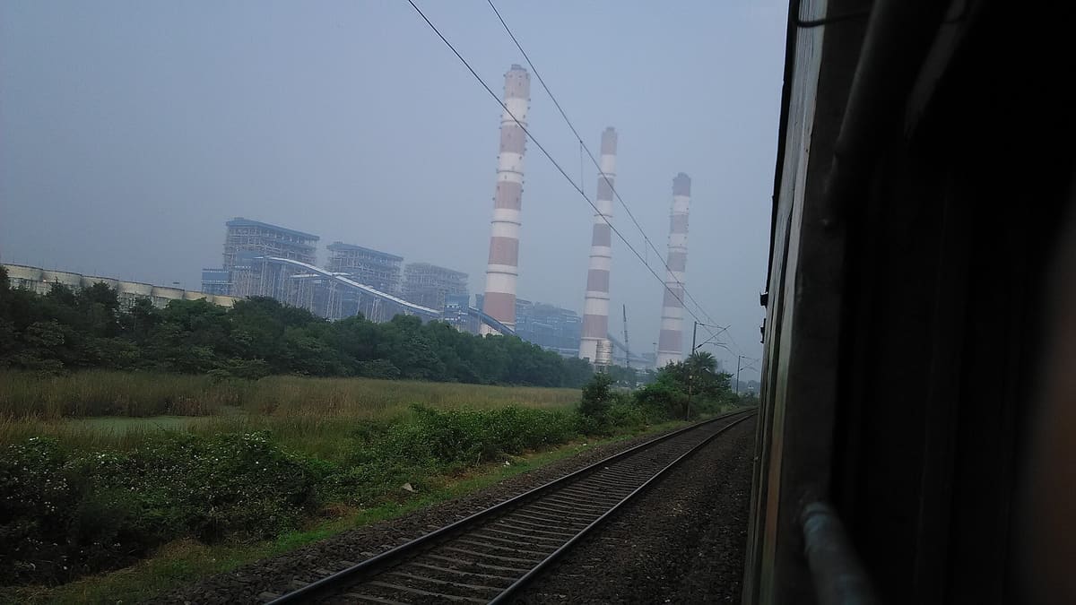 A view from a moving train of tall chimneys at NTPC's Barh power plant.